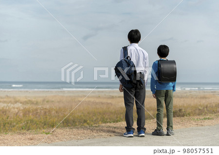 海を眺める小学生と中学生の兄弟 98057551