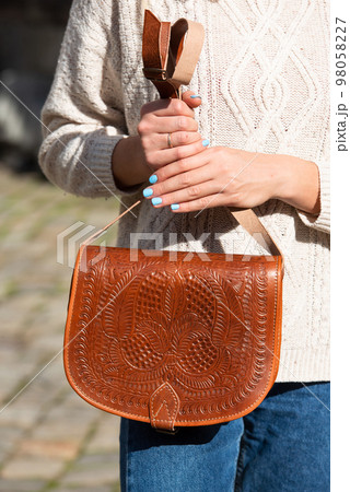 small light brown women's leather bag with a carved pattern. street photo small light brown women's leather bag with a carved pattern. street photo 98058227