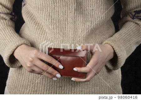Leather wallet in female hands close-up. Leather wallet in female hands close-up. 98060416