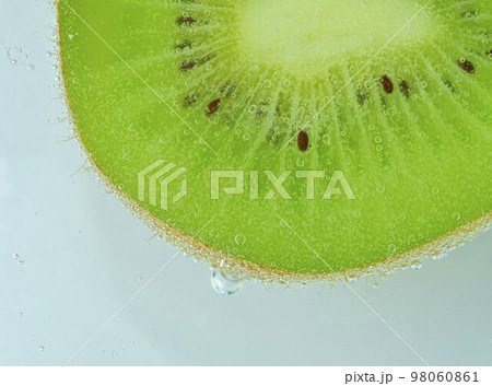Close-op of kiwi fruit with bubbles. Bright view photo. Kiwi fruit slice in water with bubbles on light background. Macro image Close-op of kiwi fruit with bubbles. Bright view photo. Kiwi fruit slice in water with bubbles on light background. Macro image 98060861