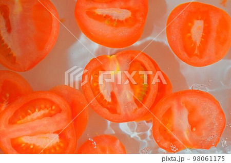 Close-up fresh slices of juicy tomato on whiteの写真素材 