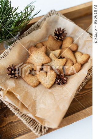 Preparation of gingerbread, different gingerbreads of different shapes lie on a wooden tray, top view. Holiday concept. 98061973