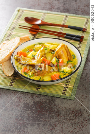 Vietnamese Chicken Curry Ca Ri Ga with tender chicken, rich curry with potatoes and carrots close-up in a plate. Vertical 98062043