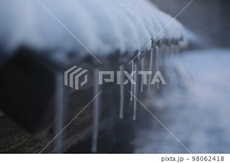 Spring background with icicles melting in the sun. Icicles close-up. Snow melting. Rustic scene in early spring 98062418