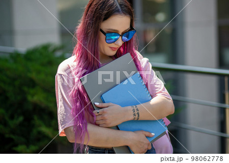 Portrait beautiful female writer dressed in casual outfit holding modern laptop in hand. 98062778