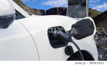 Progressive travel concept by EV car in remote mountain with charging station. 98063002