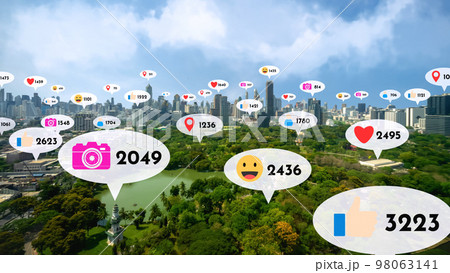 Social media icons fly over city downtown showing people reciprocity connection Social media icons fly over city downtown showing people reciprocity connection 98063141
