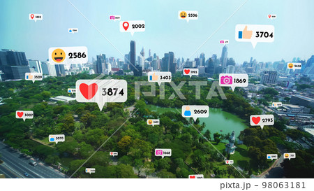 Social media icons fly over city downtown showing people reciprocity connection Social media icons fly over city downtown showing people reciprocity connection 98063181