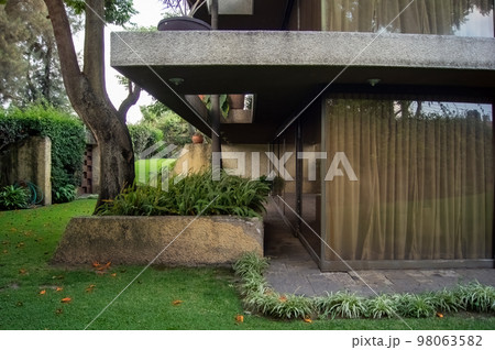 facade of a modern house with stone, staple that wraps the windows painted in gray, metal entrance, ironwork facade of a modern house with stone, staple that wraps the windows painted in gray, metal entrance, ironwork 98063582