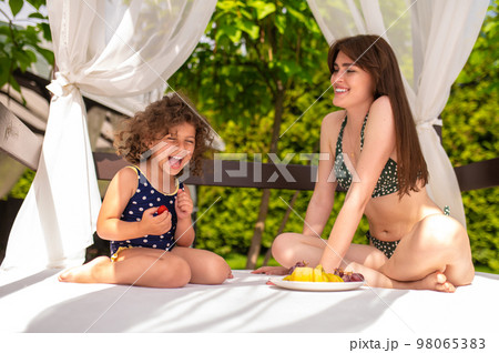 Cute family having fun in the recreation zone in a swimming pool Cute family having fun in the recreation zone in a swimming pool 98065383