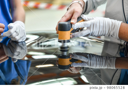 Operator holds a polisher in the hand for scratch Operator holds a polisher in the hand for scratch 98065528