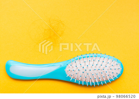 Massage comb and hank of fallen hair. Concept - hair loss. Top View 98066520