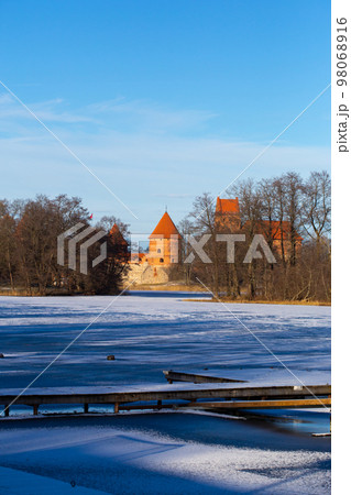 Trakai, Lithuania - 01 08 22: Island Castle in winter in sunny weather, lake covered with ice 98068916