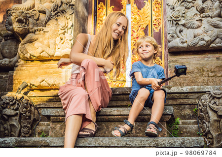 Mom and son tourists in Ubud palace, Bali - Inside the Ubud palace, Bali, Indonesia. Traveling with children concept. Traveling with children concept 98069784