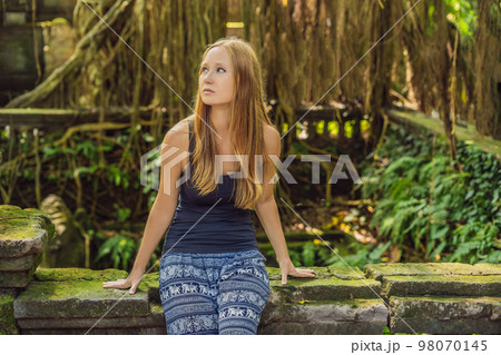 Young woman tourist explores the Monkey Forest in Ubud, Bali, Indonesia 98070145