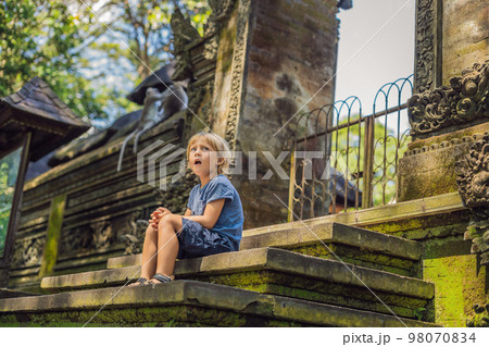Boy tourist discovering Ubud forest in Monkey forest, Bali Indonesia. Traveling with children concept Boy tourist discovering Ubud forest in Monkey forest, Bali Indonesia. Traveling with children concept 98070834