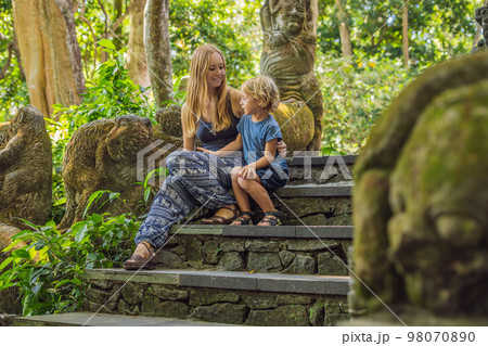 Mom and son travelers discovering Ubud forest in Monkey forest, Bali Indonesia. Traveling with children concept Mom and son travelers discovering Ubud forest in Monkey forest, Bali Indonesia. Traveling with children concept 98070890