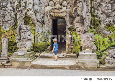 Boy tourist in Old Hindu temple of Goa Gajah near Ubud on the island of Bali, Indonesia. Travel in Bali with children concept Boy tourist in Old Hindu temple of Goa Gajah near Ubud on the island of Bali, Indonesia. Travel in Bali with children concept 98070945