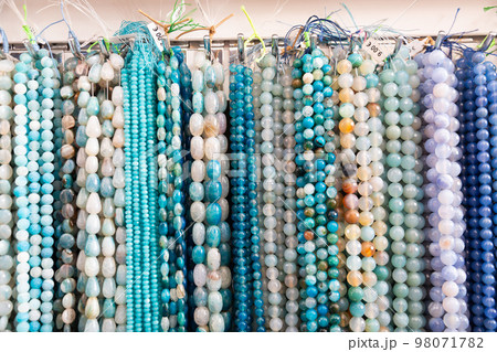 Beads from various gemstones on the showcase of jewelry store 98071782