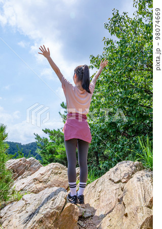 korean young women hiking and plogging_hurray hand motion on the rock korean young women hiking and plogging_hurray hand motion on the rock 98074669