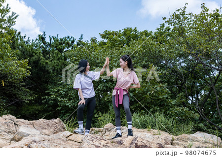 korean young women hiking and plogging_facing each other cheering hand motion 98074675