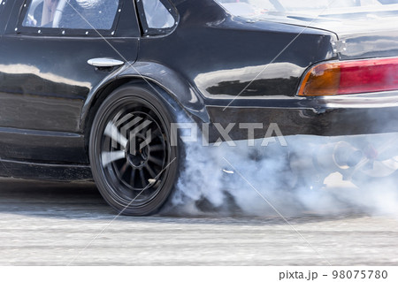 Race drift car burning tires on speed track 98075780