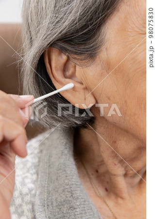 Elderly woman cleaning ear with cotton swab. Hygiene ears. Elderly woman cleaning ear with cotton swab. Hygiene ears. 98075830