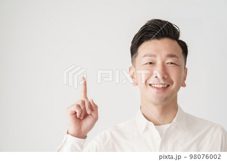 人差し指を立てるポーズをする男性 98076002