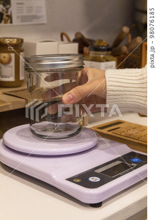 eco friendly habits hand gesture_refilling and weighing at zero waste shop 98076185