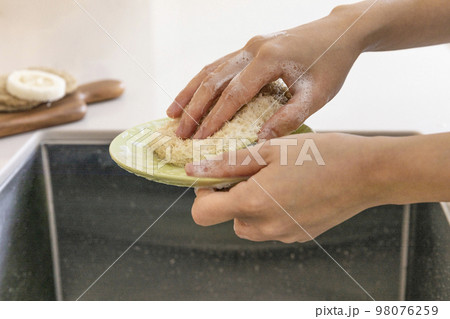 eco friendly habits hand gesture_washing dishes with an eco friendly sponge 98076259