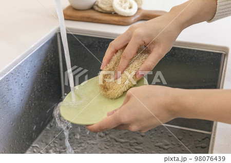 eco friendly habits hand gesture_washing dishes with an eco friendly sponge 98076439