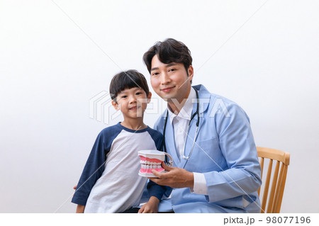 Asian Korean doctors and children holding miniatures of teeth Asian Korean doctors and children holding miniatures of teeth 98077196