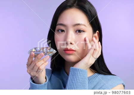 beautiful young Korean Asian woman portrait studio photo in winter skin beauty and cosmetics concept__ holding a jewel beautiful young Korean Asian woman portrait studio photo in winter skin beauty and cosmetics concept__ holding a jewel 98077603