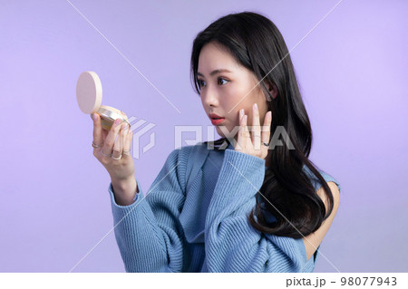beautiful young Korean Asian woman portrait studio photo in winter skin beauty and cosmetics concept__holding foundation 98077943