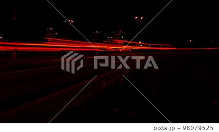 Lights of cars at night. Street line lights. Night highway city. Long exposure photograph night road. Colored bands of red light trails on the road. Background wallpaper defocused Lights of cars at night. Street line lights. Night highway city. Long exposure photograph night road. Colored bands of red light trails on the road. Background wallpaper defocused 98079525