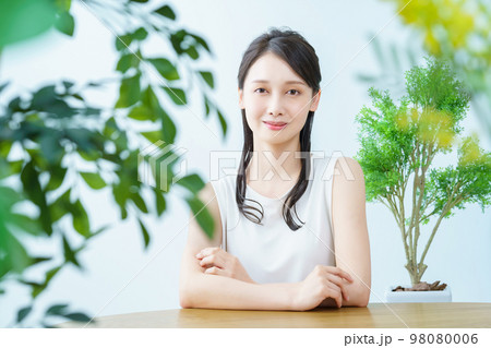 緑に囲まれた部屋で笑顔の女性 緑に囲まれた部屋で笑顔の女性 98080006