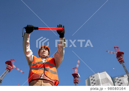 工事現場で交通誘導をする安全ベスト着用の男性 98080164