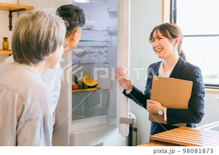 家電量販店・住宅展示場・モデルルーム・電気屋で高齢者夫婦に説明するビジネスウーマン（冷蔵庫） 98081873