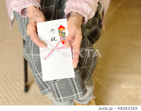 御祝儀袋を持つ高齢女性の手 98083569