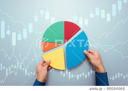 分散投資の戦略のイメージ。ポートフォリオを管理する投資家。円グラフとローソク足チャート。 98084068