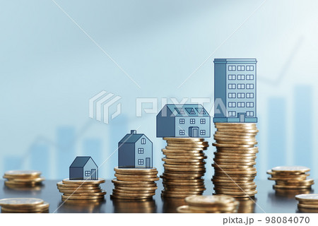 不動産投資からのリターンが増えるイメージ。成功する投資計画。積まれたコインと住宅やビルのイラスト。背 98084070