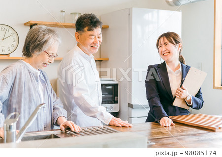 住宅展示場・モデルルーム・ハウスメーカーで高齢者夫婦に説明するビジネスウーマン(キッチン・天板) 住宅展示場・モデルルーム・ハウスメーカーで高齢者夫婦に説明するビジネスウーマン(キッチン・天板) 98085174