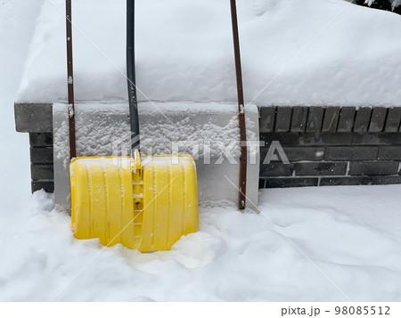 Yellow snow shovel standing in the snow Yellow snow shovel standing in the snow 98085512