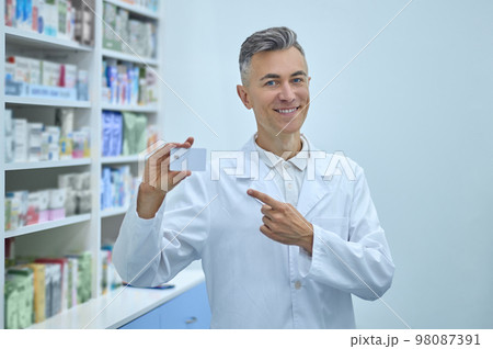 Male pharmacist in lab coat working in a drugstore Male pharmacist in lab coat working in a drugstore 98087391