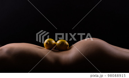 Lemon, natural vitamin c help skin whitening. Naked woman lying on her back with fruit located Lemon, natural vitamin c help skin whitening. Naked woman lying on her back with fruit located 98088915