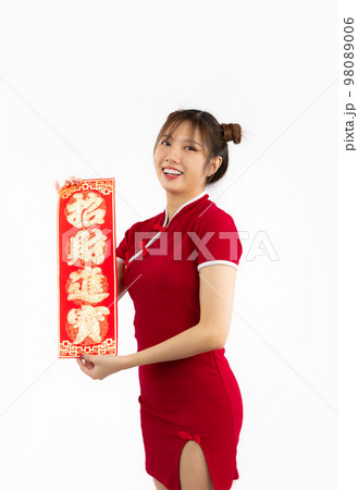 Smiling Asian woman wearing red traditional cheongsam dress presenting Chinese new year label and looking at camera isolated white background.. 98089006