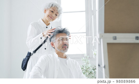 シニア男性をヘアセットするグレイヘアの美容師 シニア男性をヘアセットするグレイヘアの美容師 98089866