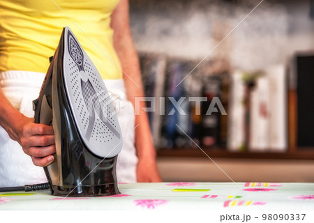 Steam from iron in hand Steam from iron in hand 98090337