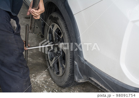 Car mechanic changing wheels in car,Tire repairer 98091754