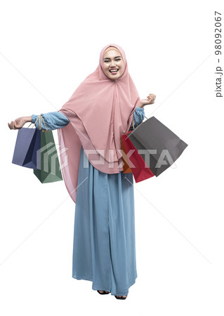 Asian Muslim woman in veil holding shopping bags 98092067